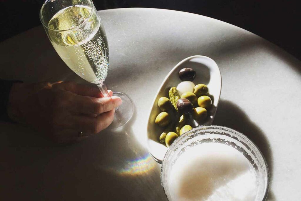 Olives, a glass of cava and a glass of beer in the afternoon sunlight